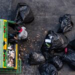 green-garbage-truck-employees-are-collecting-lot-black-garbage-bags-3-min